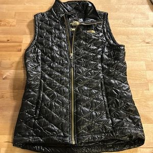 North face women’s vest size small. Black with gold zipper and gold threads.